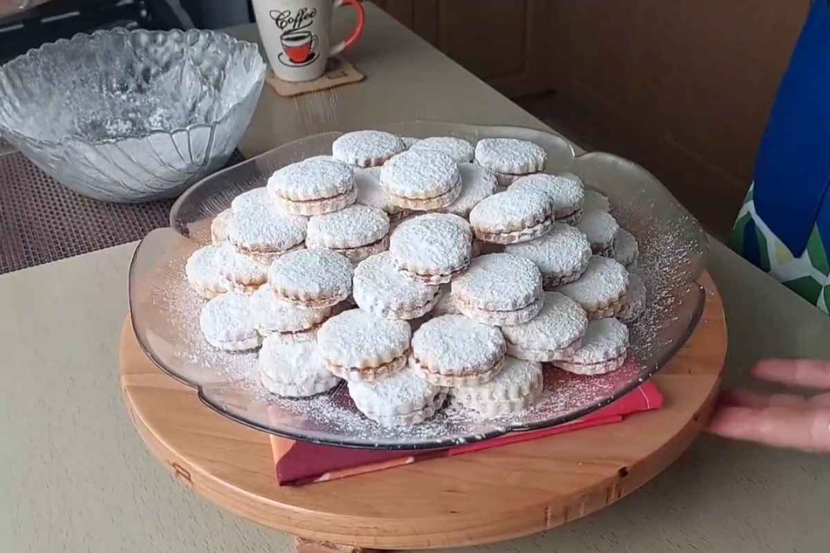 osoba posipa vanillice sa šećerom u prahu